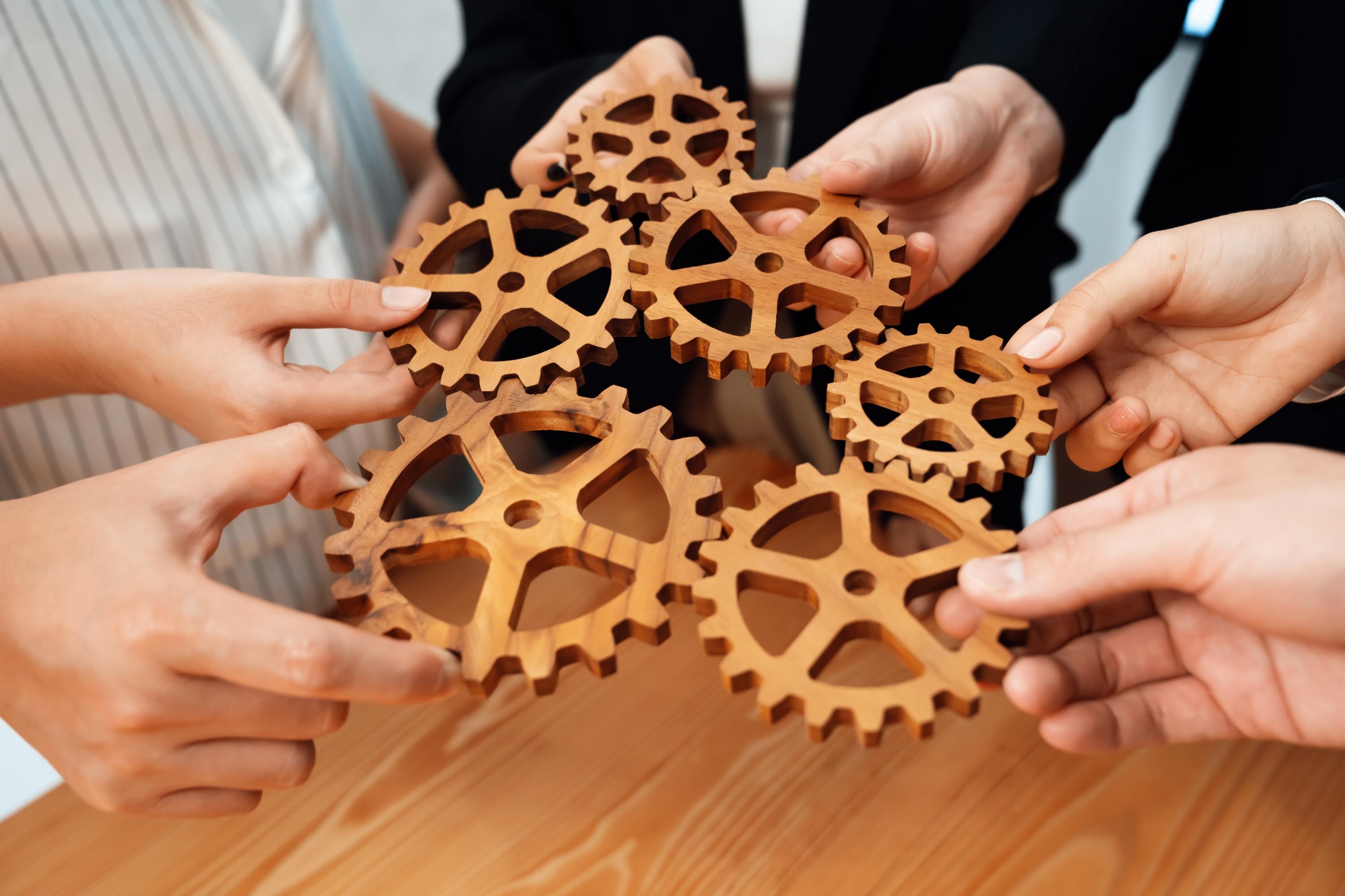Team collaborating with interlocking wooden gears